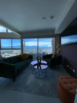 a living room with couches and a table with a view at Exclusive apartment in downtown Costa Rica in San José