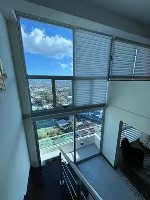 a large window in a building with a view of a city at Penthouse in San Jose Costa Rica in San José