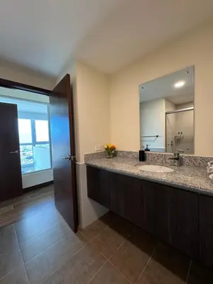 a bathroom with a sink and a large mirror at Penthouse in San Jose Costa Rica in San José
