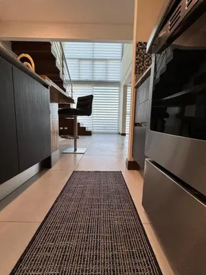 a kitchen with a stove and a rug on the floor at Penthouse in San Jose Costa Rica in San José
