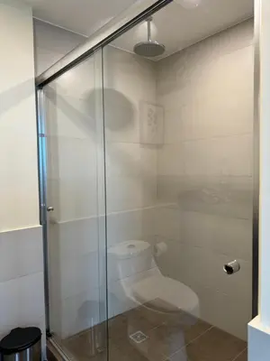 a bathroom with a toilet and a glass shower at Penthouse in San Jose Costa Rica in San José