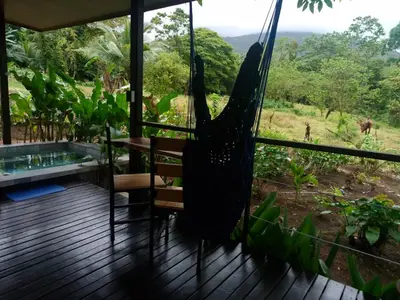 a hammock on the deck of a house with a view at Pantala Villa in Fortuna