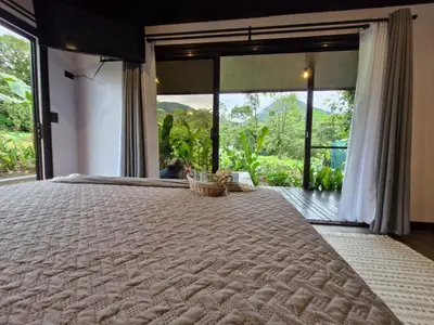 a bedroom with a large bed with a large window at Pantala Villa in Fortuna