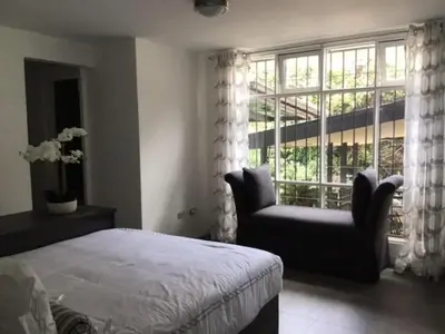 a bedroom with a bed and a chair and a window at Gitana Hermosa in San Rafael