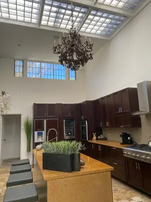 a large kitchen with wooden cabinets and a chandelier at Gitana Hermosa in San Rafael