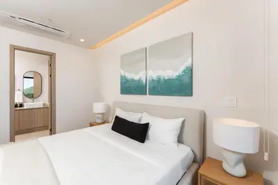 a bedroom with a white bed and a mirror at Kokito at Naumi, Ocean Views & Beach Club in Coco