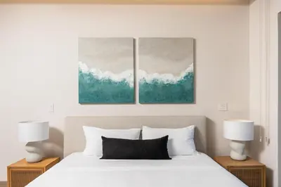 a bedroom with a bed and two paintings on the wall at Kokito at Naumi, Ocean Views & Beach Club in Coco