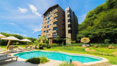 a hotel with a swimming pool and a building at Kokito at Naumi, Ocean Views & Beach Club in Coco