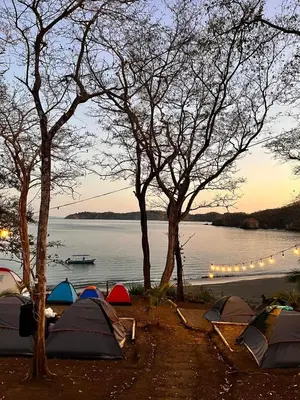 a group of tents on the shore of a lake at Tour de Bioluminisciencia con Camping