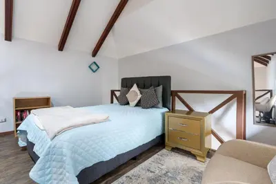 a bedroom with a bed and a chair at Modern Island-Themed Condo with Floor-to-Ceiling Windows & Garden and Pool Views Within Walking Distance of the Beach in Coco