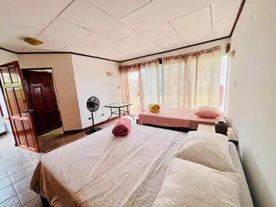 a bedroom with two beds and a window at Casa Las Brisas del Miravalles in Bagaces