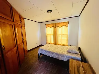 a small bedroom with a bed and a window at Casa Las Brisas del Miravalles in Bagaces