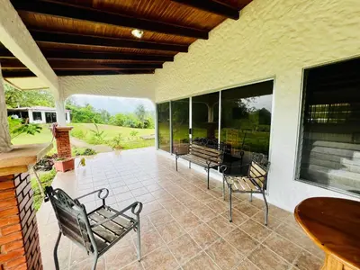 a patio with two chairs and a table at Casa Las Brisas del Miravalles in Bagaces