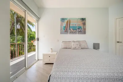 a bedroom with a bed and a large window at Twin Dolphins 2A in Playa Flamingo