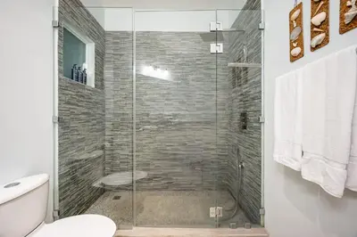 a bathroom with a glass shower with a toilet at Twin Dolphins 2A in Playa Flamingo