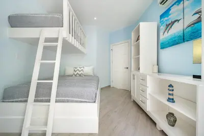 a bedroom with a bunk bed and a ladder at Twin Dolphins 2A in Playa Flamingo