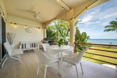 a patio with a table and chairs and the ocean at Twin Dolphins 2A in Playa Flamingo