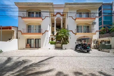 a house with a car parked in front of it at Twin Dolphins 2A in Playa Flamingo