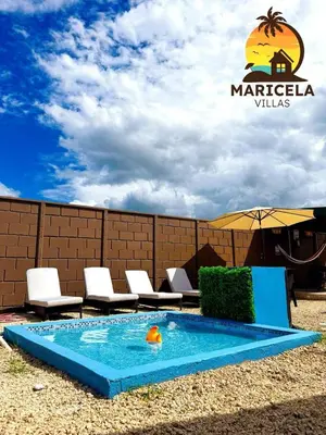 a swimming pool with chairs and an umbrella at Villas Maricela Guanacaste in Chorro