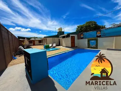 a swimming pool with a television in front of a building at Villas Maricela Guanacaste in Chorro