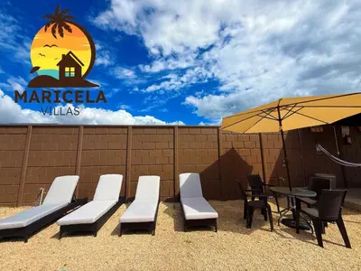 a patio with a table and chairs and an umbrella at Villas Maricela Guanacaste in Chorro