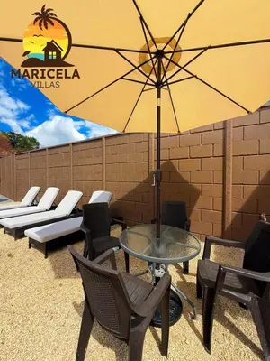 a table and chairs with an umbrella on a patio at Villas Maricela Guanacaste in Chorro