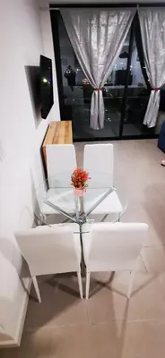 a glass table with two white chairs and a vase on it at Apartamento Bo Escalante 803 in San José