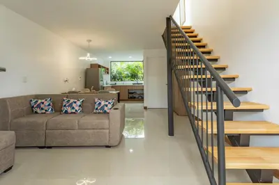 a living room with a couch and a staircase at Sweet Dreams the Arenal in Fortuna