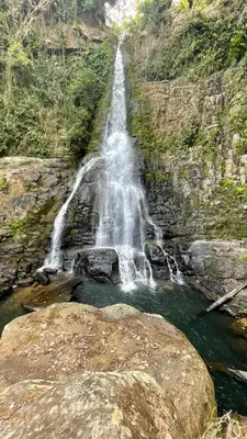 a waterfall on the side of a mountain with rocks at La jungla ecolodge in San Juan