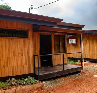 a wooden house with a porch and a balcony at La jungla ecolodge in San Juan
