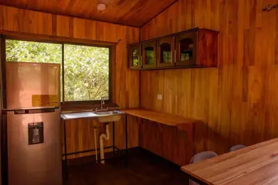 a kitchen with wooden walls and a sink and a window at La jungla ecolodge in San Juan