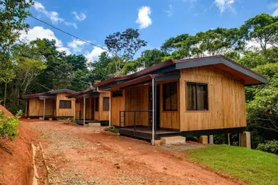a row of wooden houses on a dirt road at La jungla ecolodge in San Juan