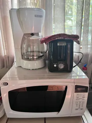 a blender and a toaster sitting on top of a microwave at Hotel Villas de la Colina in Atenas