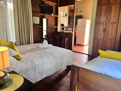a living room with a bed and a kitchen at Hotel Villas de la Colina in Atenas