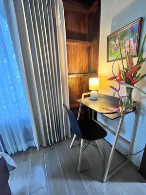 a desk with a lamp and a chair in a room at Hotel Villas de la Colina in Atenas