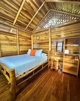 a bedroom with a bed in a log cabin at Hanging Rustic Cabin with Balcony and terrace #4 in Fortuna