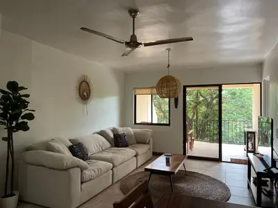 a living room with a couch and a ceiling fan at Serena Suites L2 Playas del Coco in Coco
