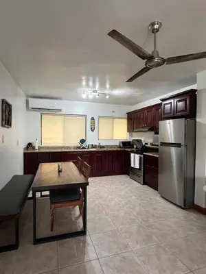 a kitchen with a table and a stainless steel refrigerator at Serena Suites L2 Playas del Coco in Coco