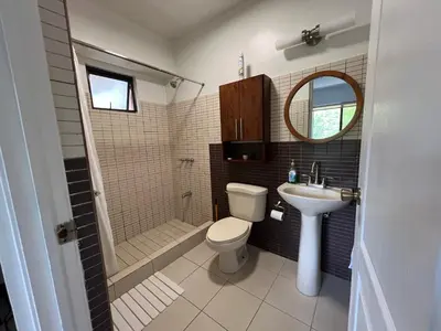 a bathroom with a toilet and a shower and a sink at Serena Suites L2 Playas del Coco in Coco