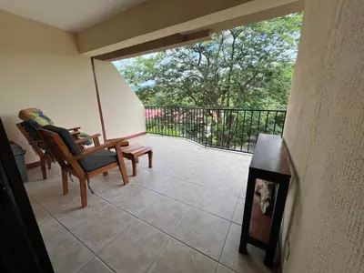 a room with a balcony with chairs and a table at Serena Suites L2 Playas del Coco in Coco