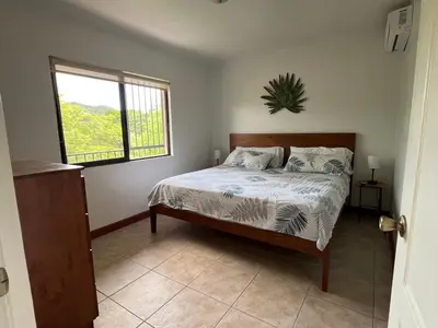a bedroom with a bed and a window at Serena Suites L2 Playas del Coco in Coco