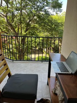 a laptop computer sitting on a desk on a balcony at Serena Suites L2 Playas del Coco in Coco