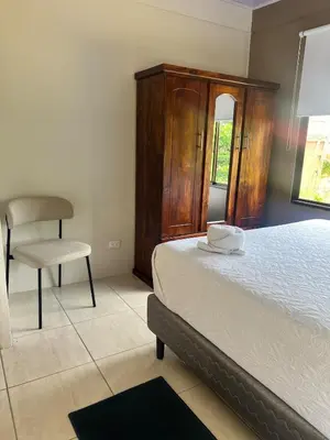 a bedroom with a bed and a chair at Apartamento del sol #3 in Tilarán