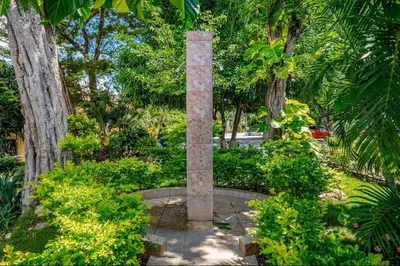 a stone pillar in the middle of a park with trees at Sweet Dreams #49 Playa Ocotal in Coco