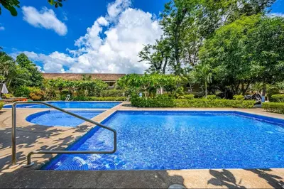 a swimming pool with blue water in a yard at Sweet Dreams #5 Playa Ocotal in Coco