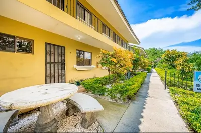 a stone bench in front of a yellow building at Sweet Dreams #5 Playa Ocotal in Coco