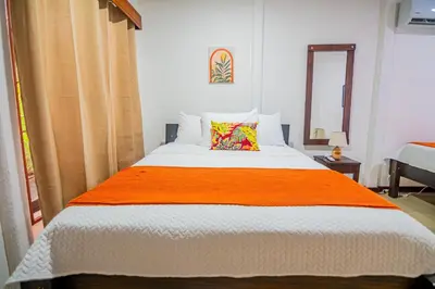 a bedroom with a large bed with an orange blanket at Rustic Ranch in Fortuna