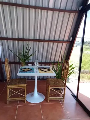 a table and chairs in a room with a window at A-frame cabin in Palma