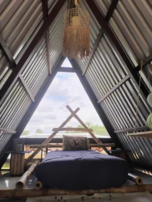 a bed in a room with a large window at A-frame cabin in Palma
