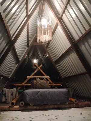 a chandelier hangs from the ceiling of a wooden attic at A-frame cabin in Palma